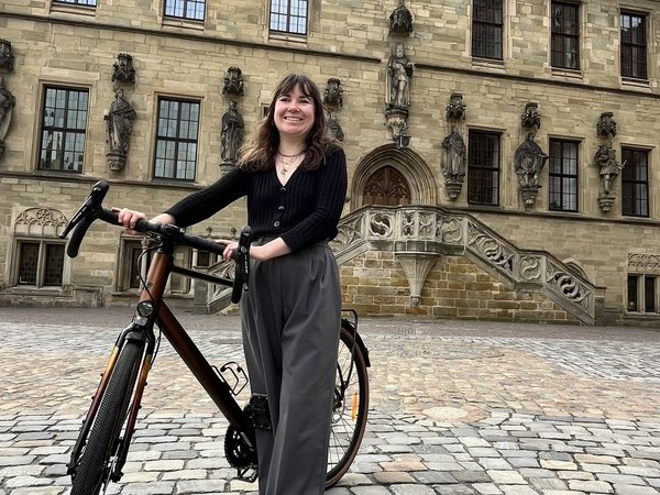 Romane Dantec, Osnabrücks Städtebotschafterin aus Angers, mit einem Fahrrad vor dem Osnabrücker Rathaus.