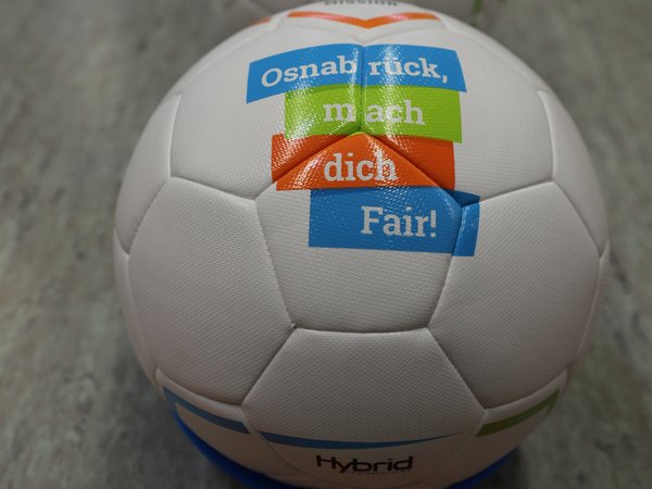 Ein Fußball liegt auf dem Boden einer Sporthalle.